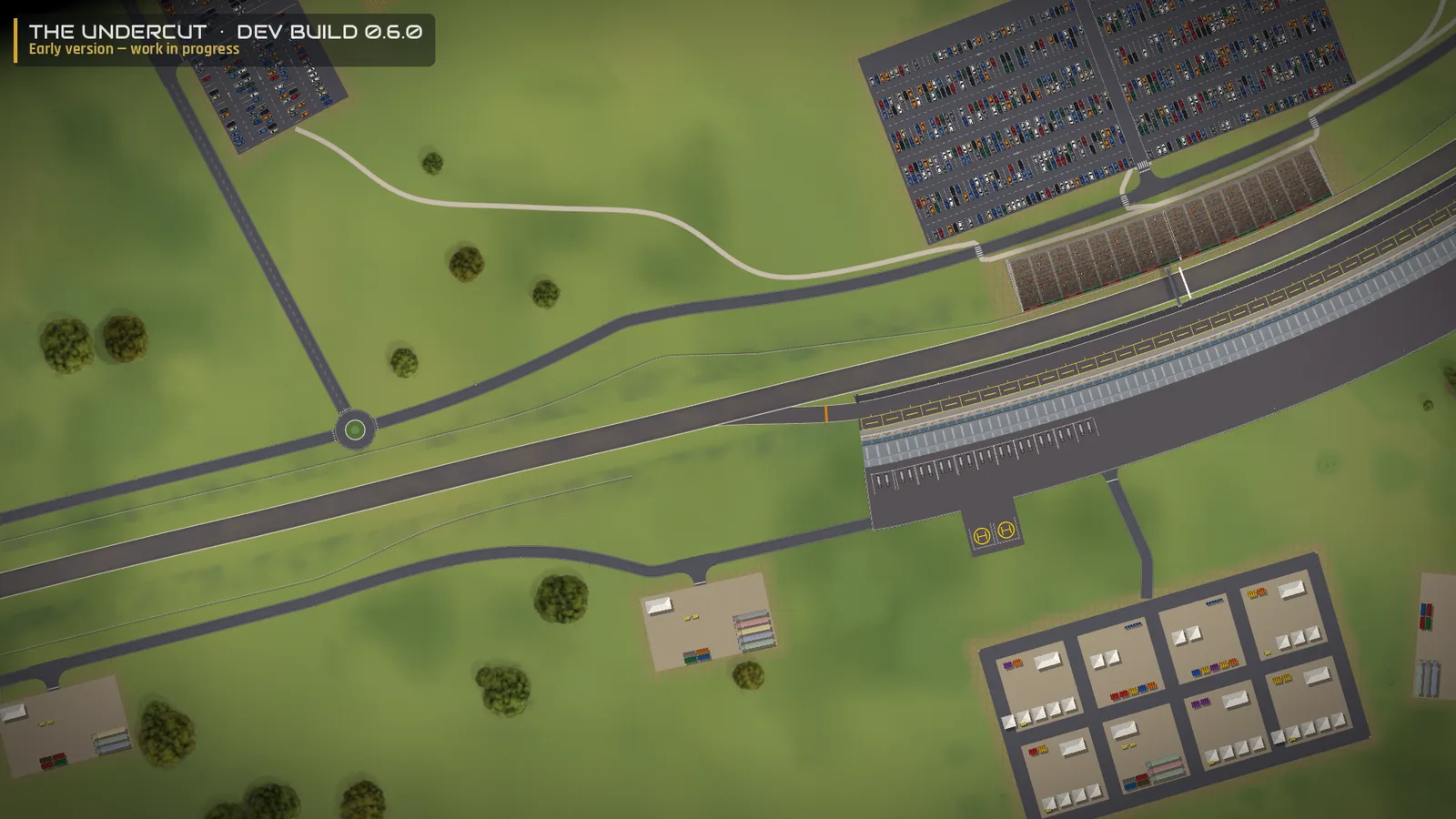 The Undercut 0.6.0 dev build — the start-finish straight: the main grandstand and a car park packed with cars, the pit building and pit lane, the helipad, and the paddock with its team compounds
